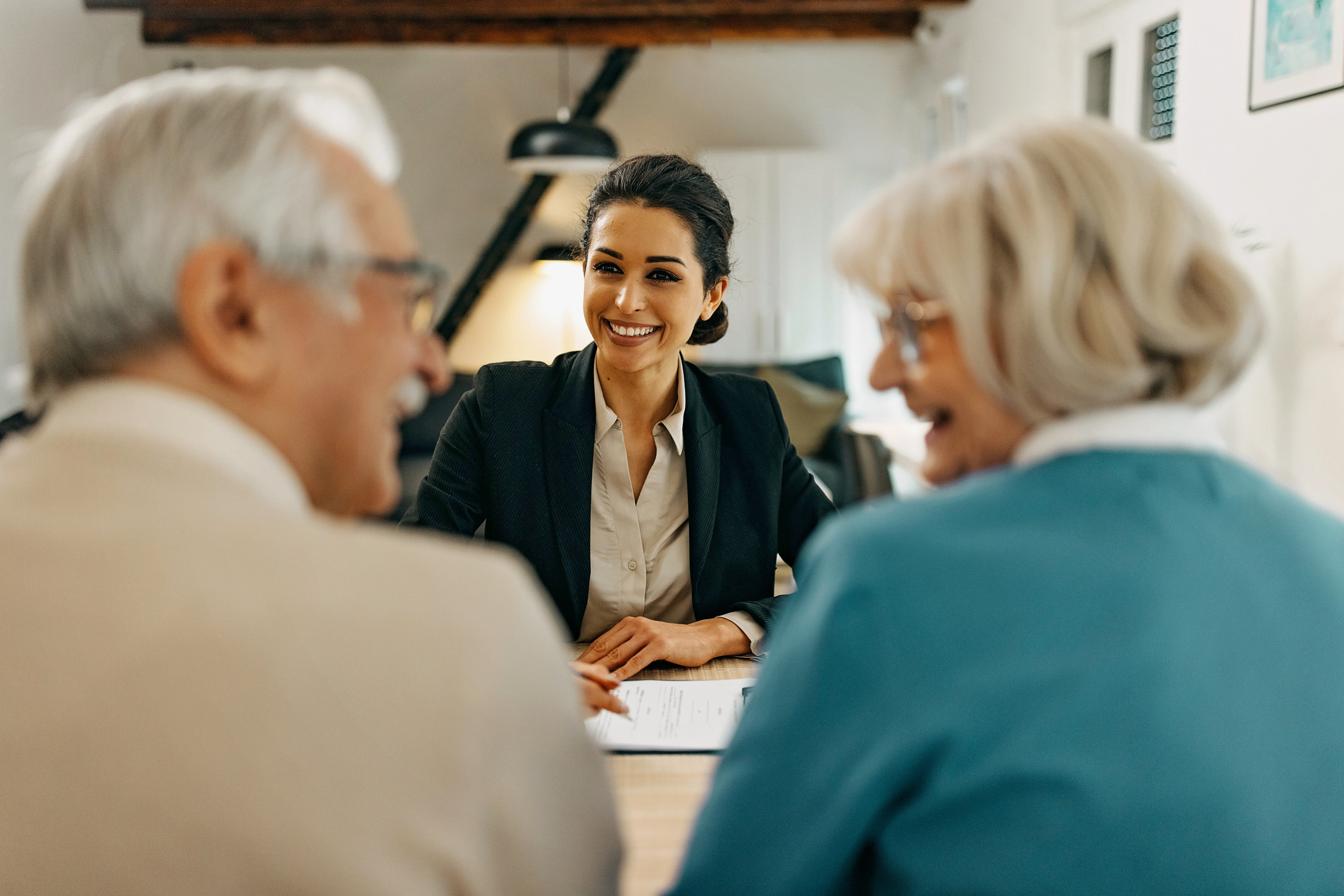 Senior couple consults with female real estate agent